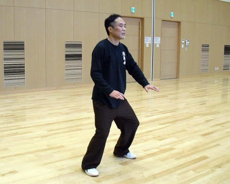太極拳の站樁の一つである下按樁の写真